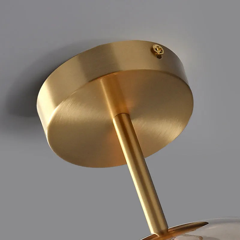 Close up of the round brushed brass ceiling plate and drop rod on the Belvo ceiling light