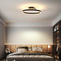 Soleno Circle Ceiling Light lit above a bed in a warm neutral bedroom