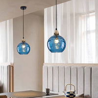 Two Riplo blue glass pendants hanging at different heights over a dining table