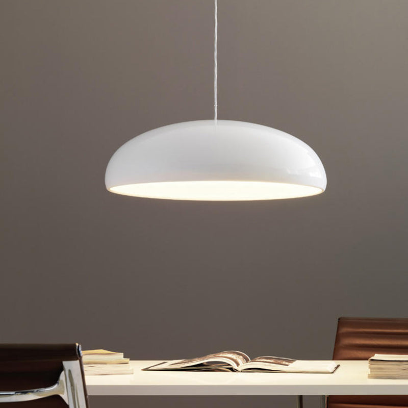 Liro white dome pendant light hanging above a desk against a warm grey wall
