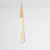 Close view of the Golvara Teardrop Pendant Light showing the ribbed gold cone and glowing crystal drop