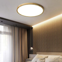 Aveno round flush mount light glowing warm in a slatted timber bedroom