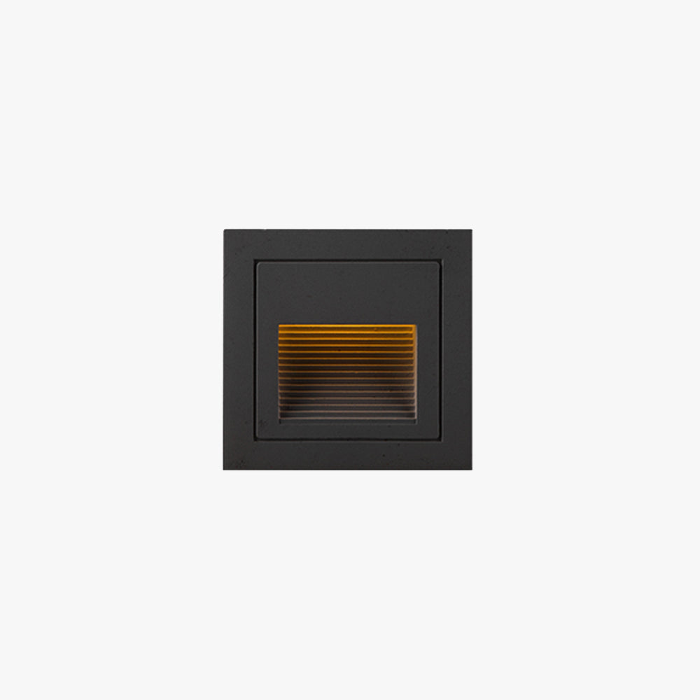 Steva Square Outdoor Step Light in black on a plain white background, louvred aperture glowing warm