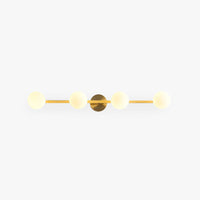Sevra four globe vanity wall light in brass on a plain white background