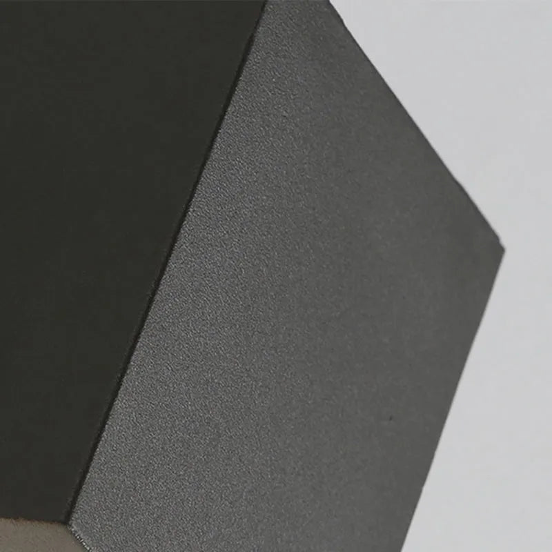 Close-up of the matt black textured metal edge and square corner of the Dovra wall light