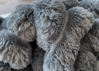 Macro photograph of the actual Nordo fabric, showing the curled coral fleece fibres and the stitched channel that forms each rib