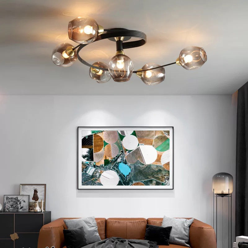 Orvello amber glass cluster ceiling light lit above a tan leather sofa in a living room