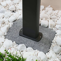 Base of the Mairo path light fixed to a paving slab surrounded by white garden pebbles
