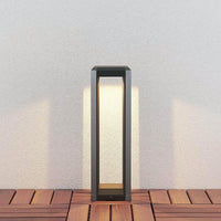 Ryda 50 cm bollard light on timber decking casting a warm downward glow onto a pale wall