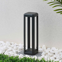 Ryda bollard light switched off, showing the slim anthracite open frame in a garden pebble bed