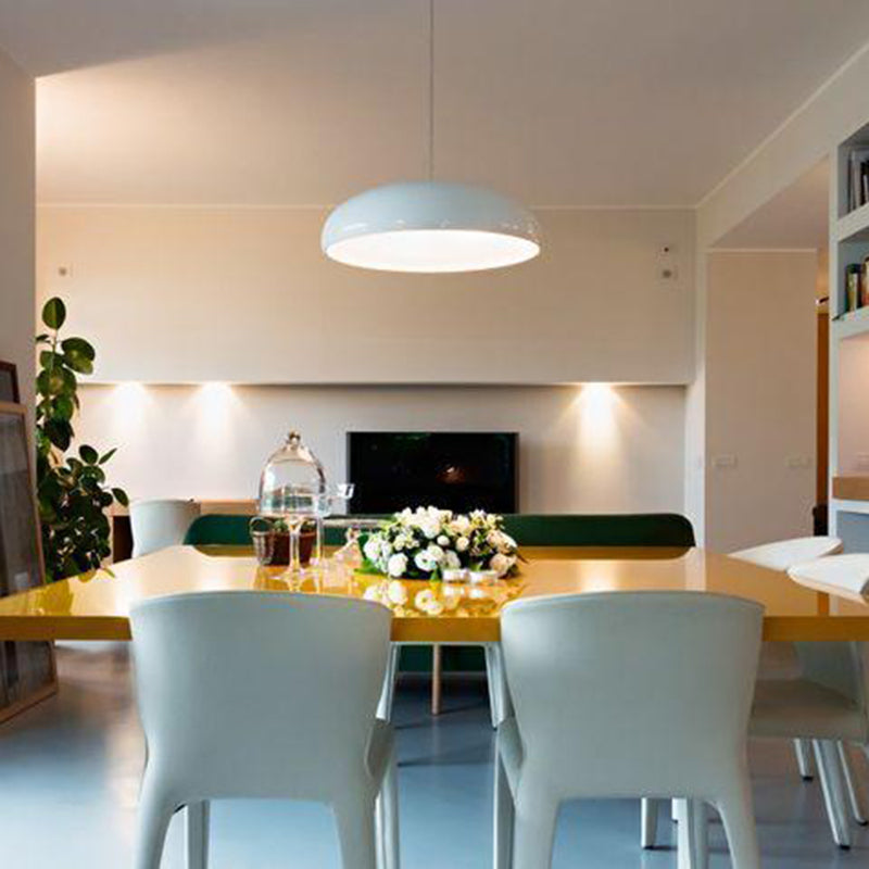 Liro white dome pendant light over a dining table in a bright open plan living room