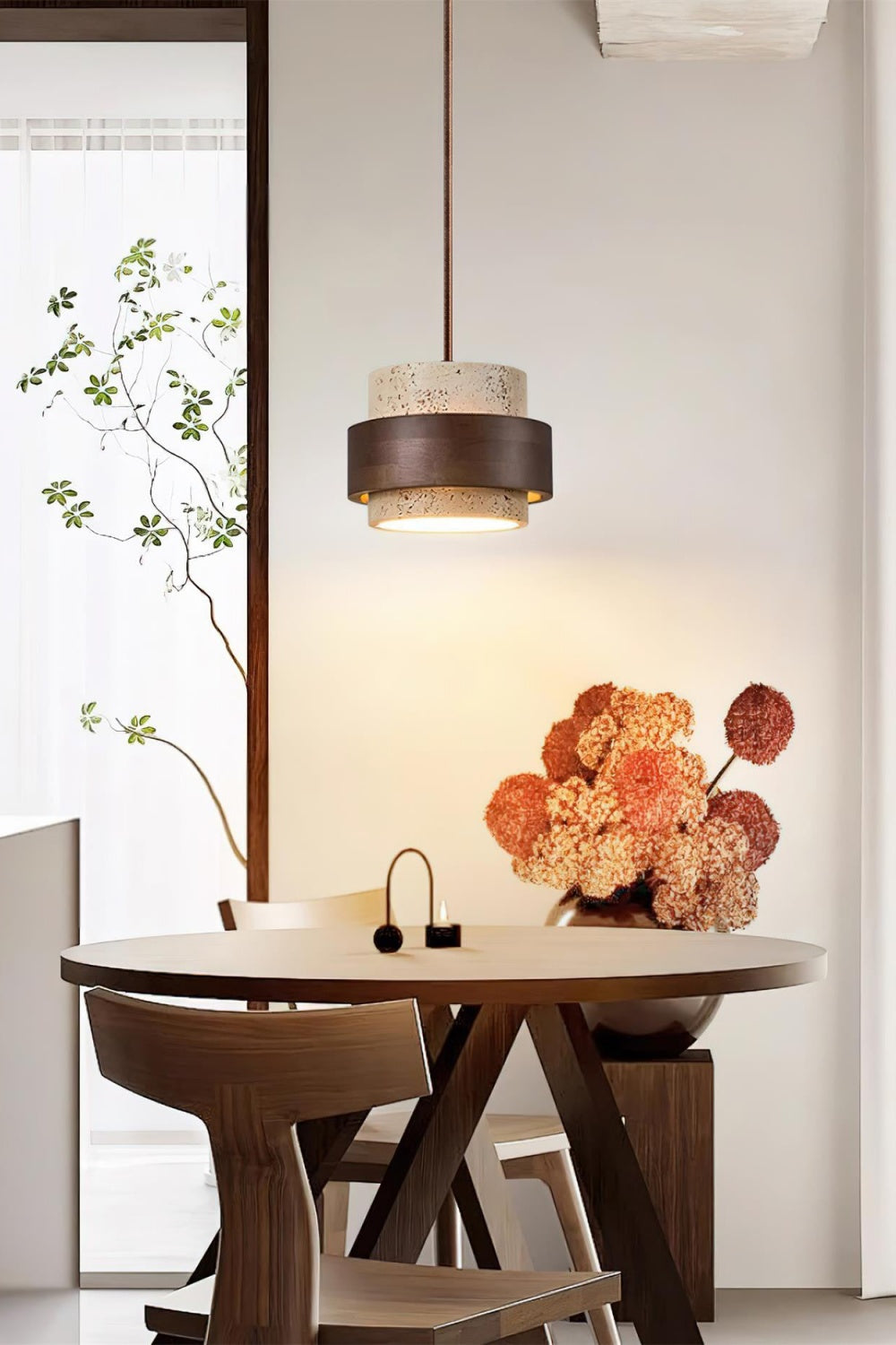 Trava stone pendant light hanging over a round wooden dining table