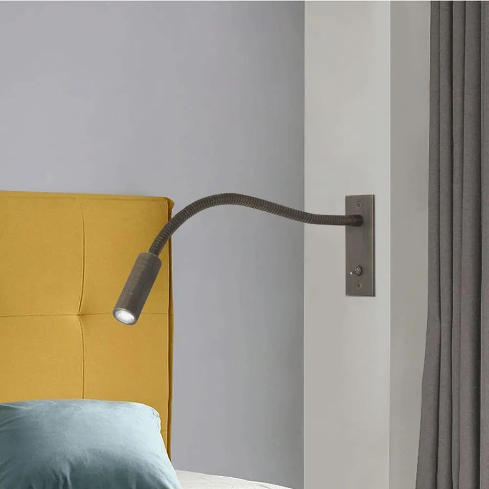 Vexo bronze reading wall light mounted beside a bed with a yellow headboard