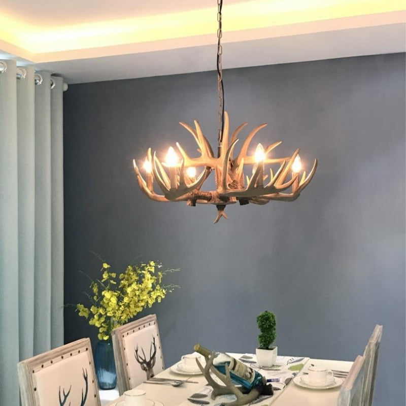 Stagra antler chandelier hanging above a dining table in a grey room