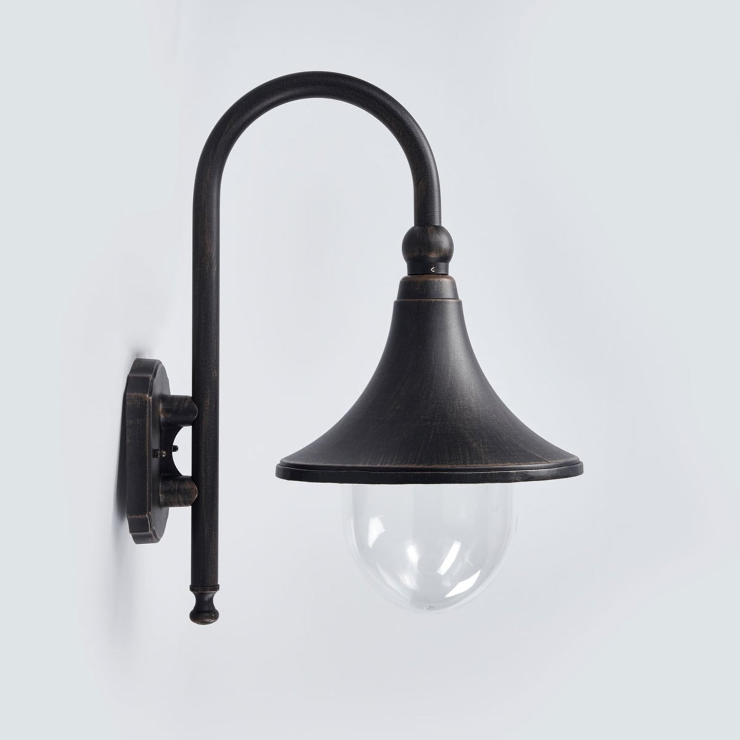 Dafo antique outdoor wall light mounted on a white rendered wall and lit at dusk beside a house