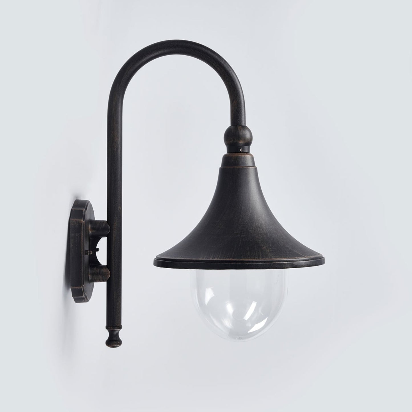 Dafo antique outdoor wall light mounted on a white rendered wall and lit at dusk beside a house