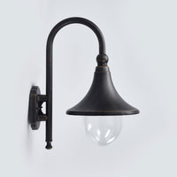 Dafo antique outdoor wall light mounted on a white rendered wall and lit at dusk beside a house