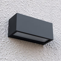 Angled close-up of the Bexa outdoor wall light on textured render, showing the frosted diffuser recessed along the lower edge