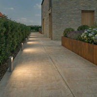 Row of Leyo Pedestal Path Lights lighting a paved walkway at dusk