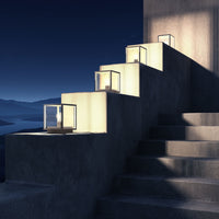 Four Anle Glass Pillar Lights lit at night along a stepped terrace wall overlooking a bay