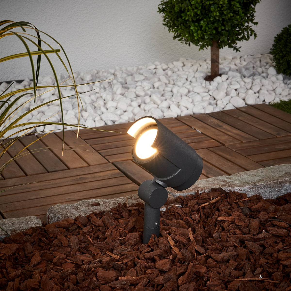Batra Garden Spike Light angled over decking with its beam lit at dusk