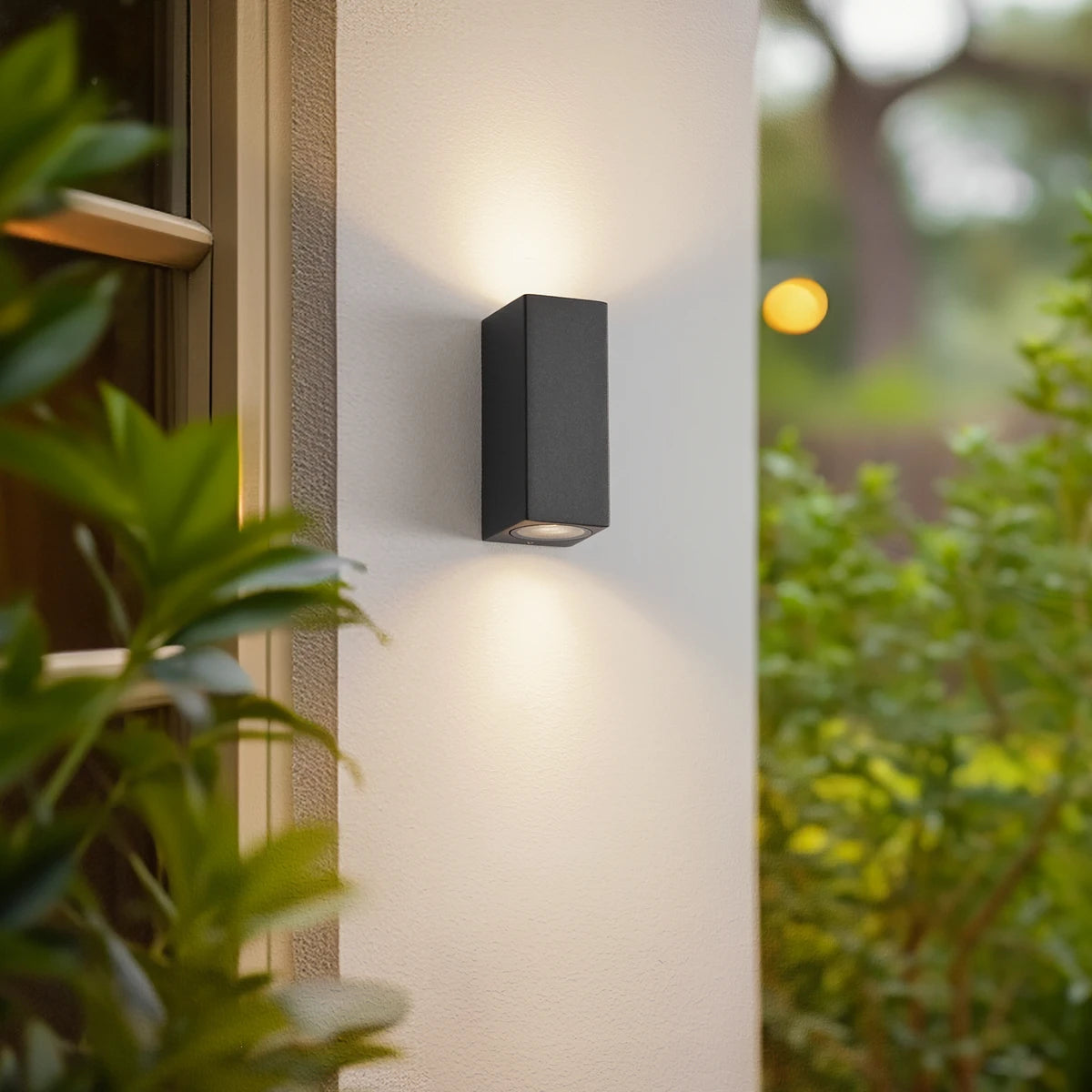 Xato outdoor wall light lit beside a doorway casting light up and down the wall