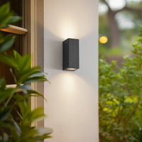 Xato outdoor wall light lit beside a doorway casting light up and down the wall