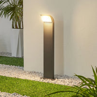 Tilo path light lit at dusk beside a gravel border and lawn