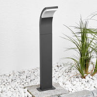 Timo path post light installed beside white gravel and ornamental grass against a rendered garden wall