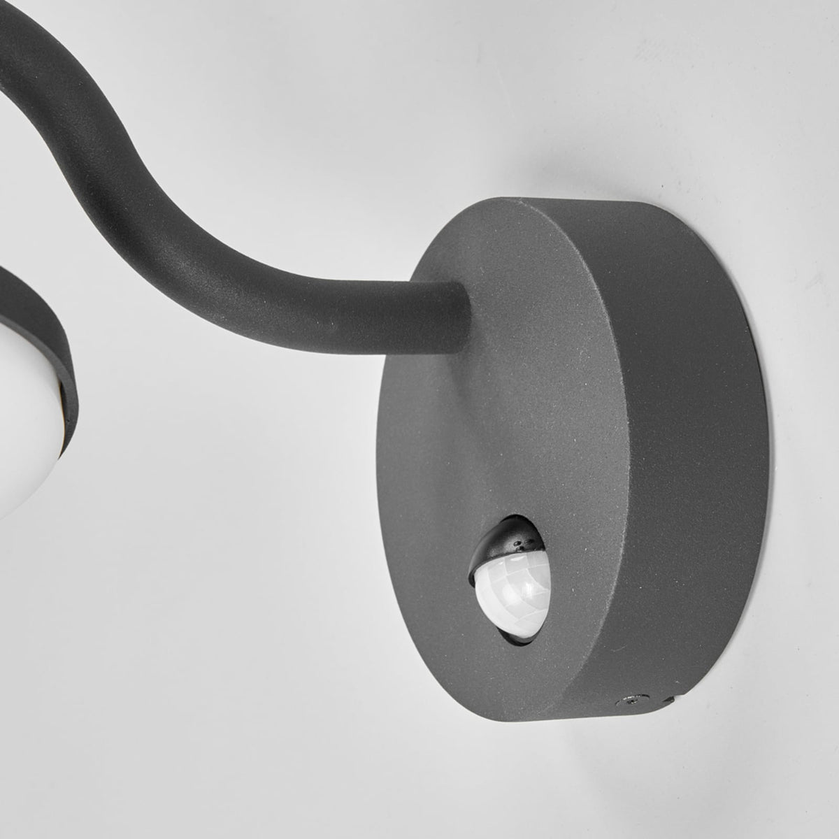 Close detail of the Finno round wall mount with the built in motion detector lens