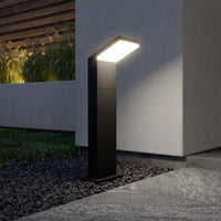 Yola Path Post Light lit at dusk beside a rendered garden wall and gravel bed