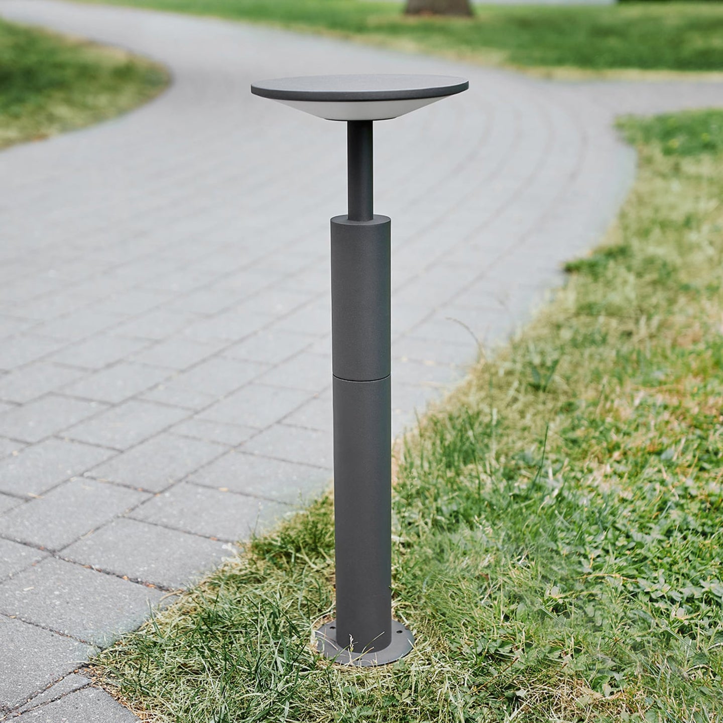 Feno anthracite path post light unlit in daylight at the edge of a paved walkway