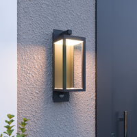 Denro sensor wall light lit at dusk on a textured render wall beside a dark front door
