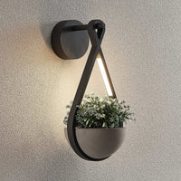 Norva Stone Planter Outdoor Wall Light lit at dusk with planting in the concrete bowl