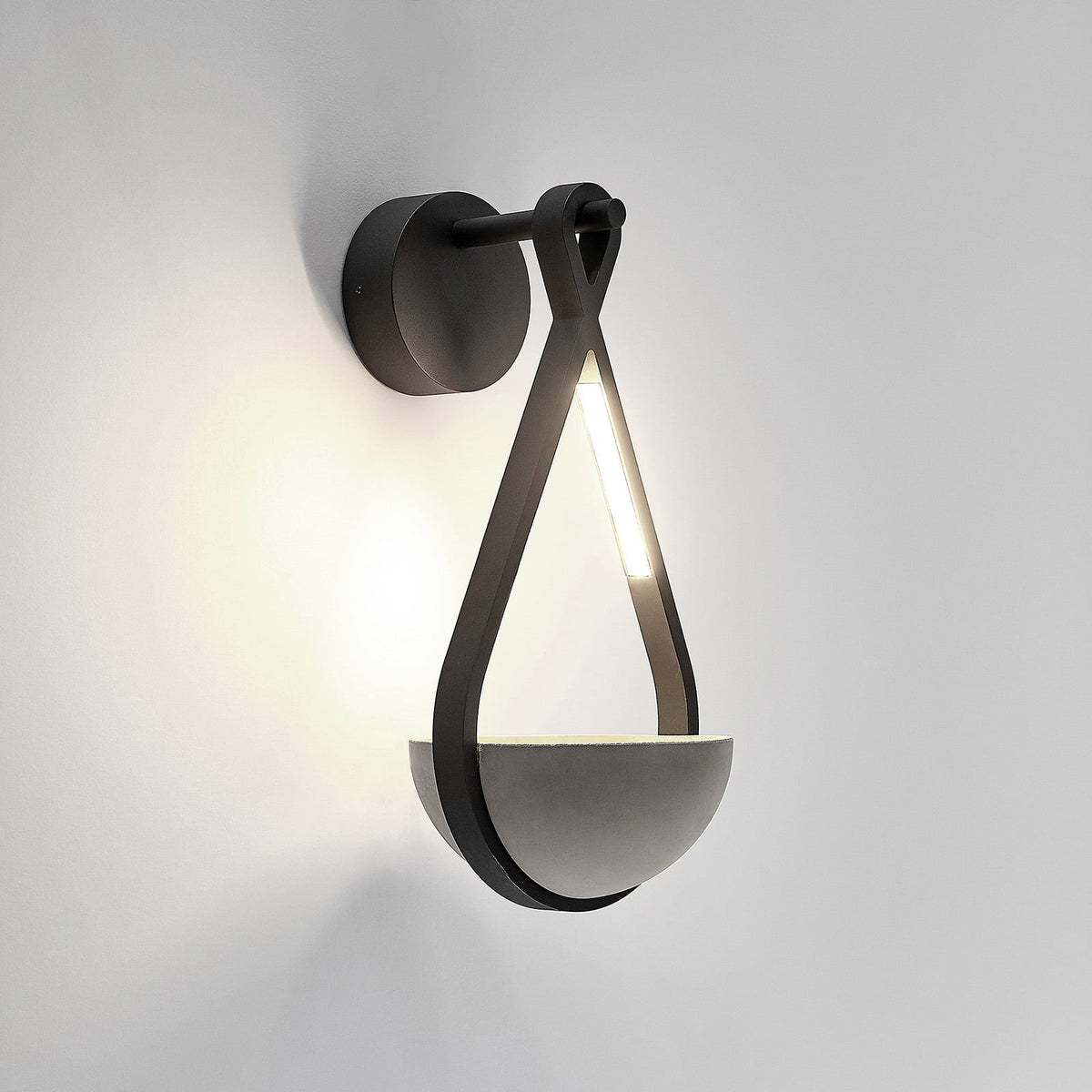Norva Stone Planter Outdoor Wall Light on a plain background with the LED lit above the concrete bowl