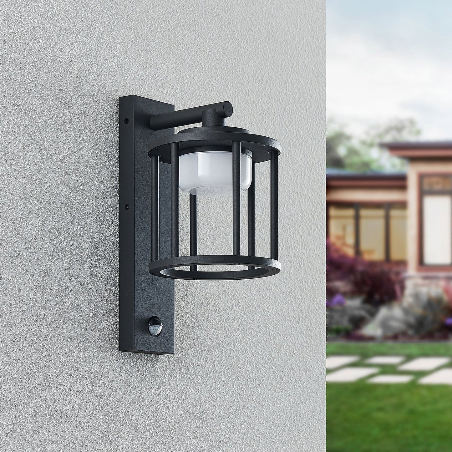 Berno anthracite cage wall light unlit on a grey rendered wall with the motion sensor visible on the bracket
