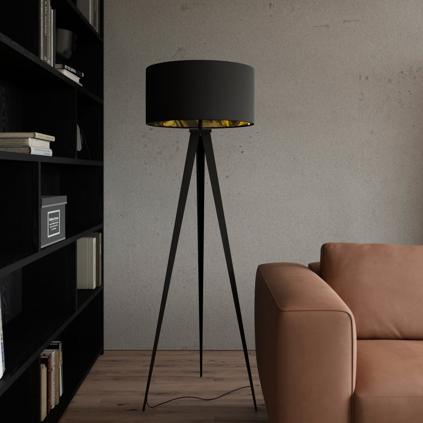 Beno tripod floor lamp beside a tan leather sofa and black bookshelf against a concrete wall