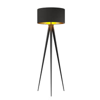 Beno tripod floor lamp on a white background, black drum shade with gold lining on three slim black tapered legs