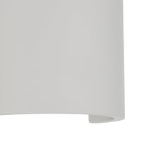 Close-up of the Cova wall light showing the chalky matte plaster surface and the curved lower opening