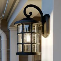 Ankor outdoor wall lantern lit at dusk on a pale clapboard house wall