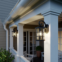 Two Ankor lanterns lighting a covered porch with white railings and a seating area