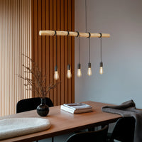 Rovo wood rope pendant light hanging above a walnut dining table with warm filament bulbs lit