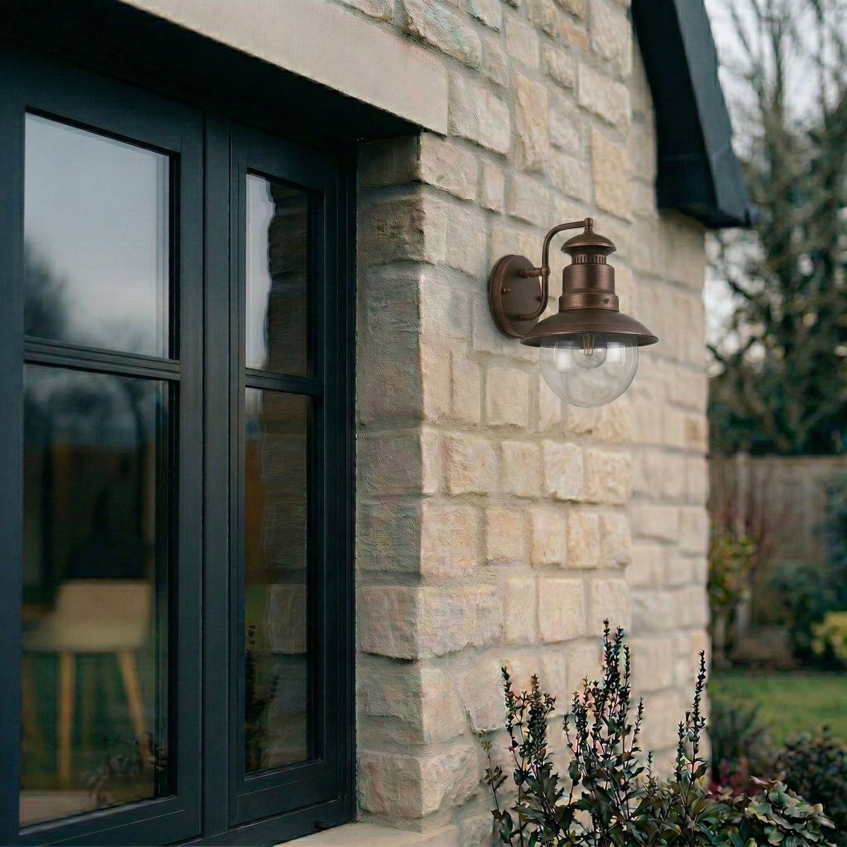 Erdo Rust Lantern Outdoor Wall Light fitted beside a window on a stone cottage wall