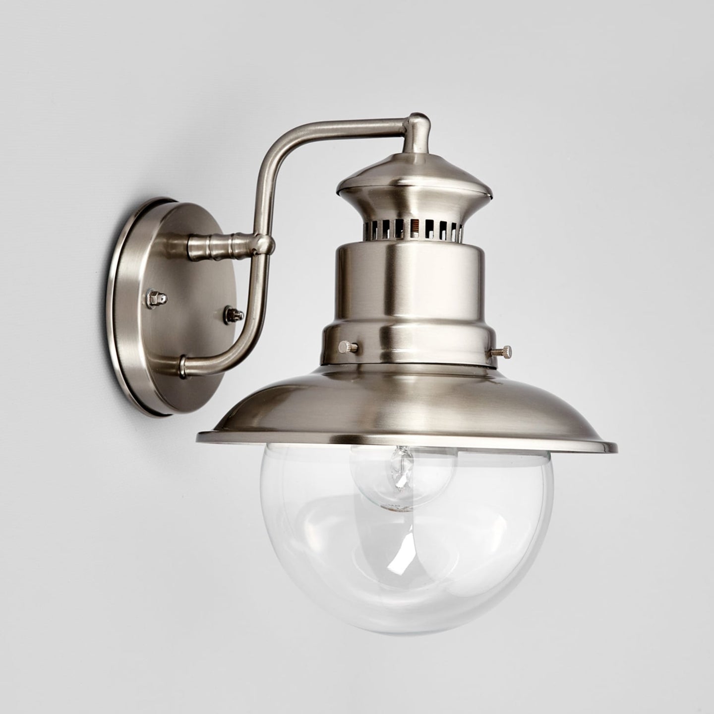 Three quarter view of the Gwena outdoor wall light showing the curved steel wall arm and round backplate