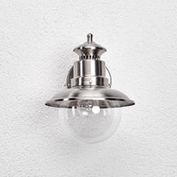 Front view of the Gwena stainless steel wall lantern showing the wide shade capping the round glass globe