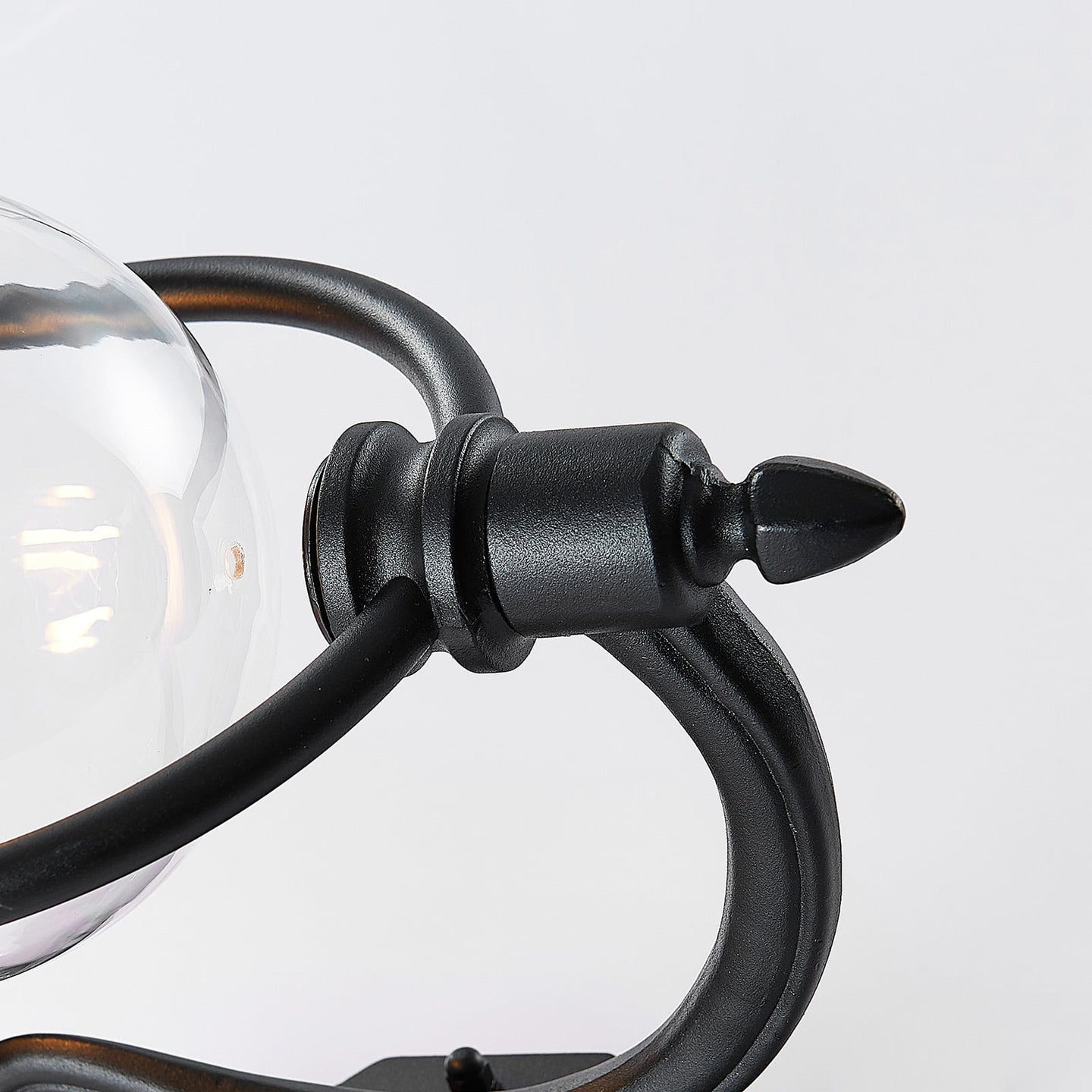 Close detail of the Koma black cast bracket arm and clear glass bowl