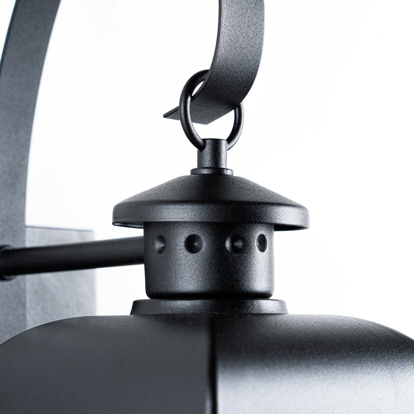 Close view of the Merto lantern finial, ring and curved black scroll arm