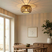Cana rattan flush mount ceiling light lit above a dining table