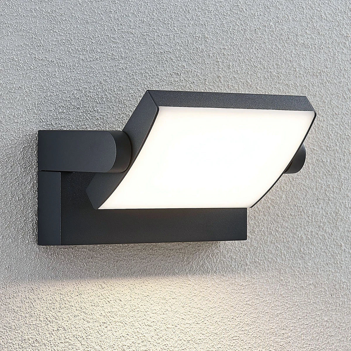 Shiro outdoor wall light mounted on a rendered wall with the head angled downwards