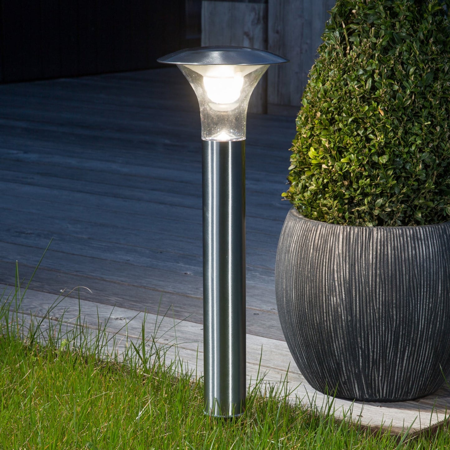 Jolo solar spike light standing in a lawn beside a planter in daylight showing the full 66 cm height